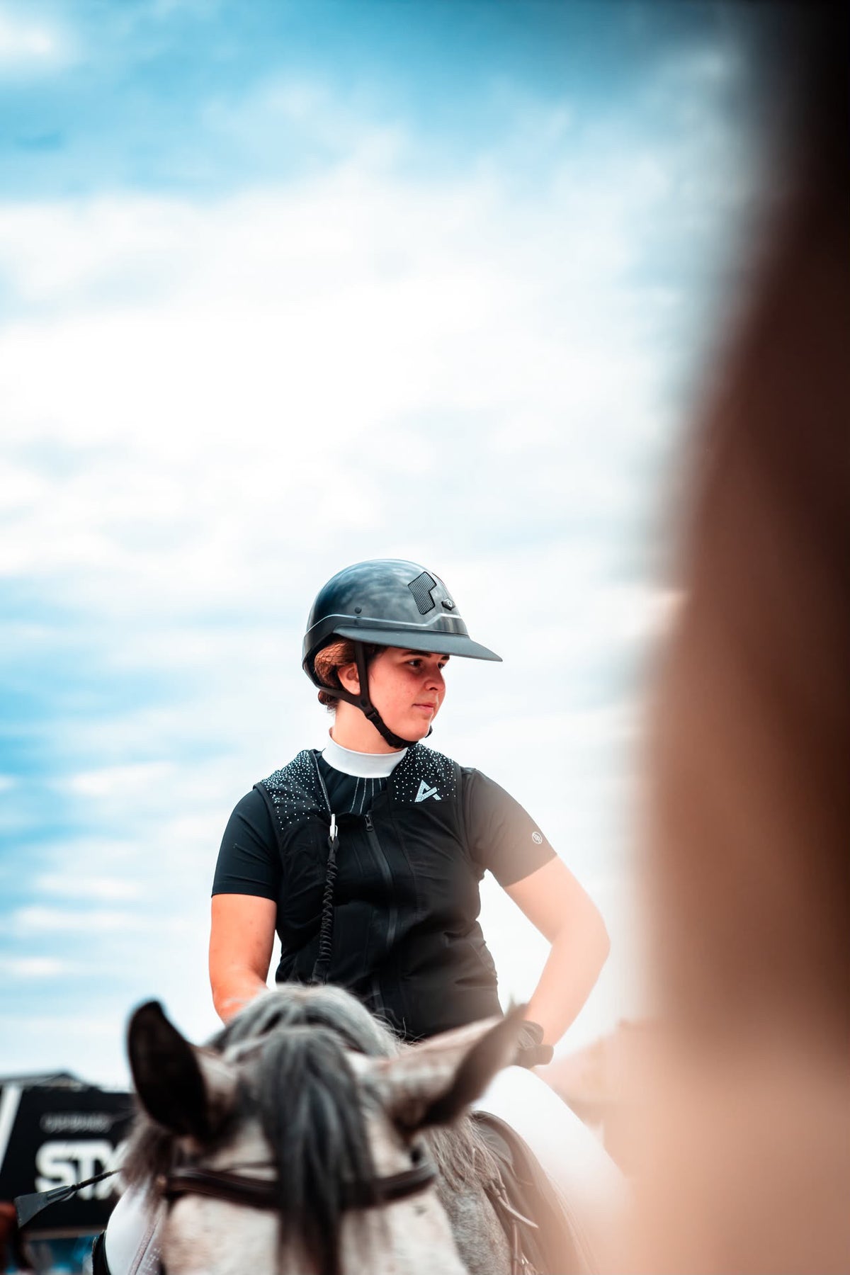 Cavalière à cheval portant le gilet airbag d’équitation à cristaux WATERFALL AXION Equestrian