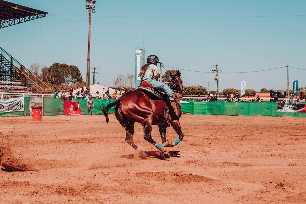 Jeune cavalière casquée à cheval lors d'une épreuve équestre