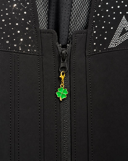 
Charm AXION quadrifoglio verde con moschettone dorato, agganciato a un tirazip nero.